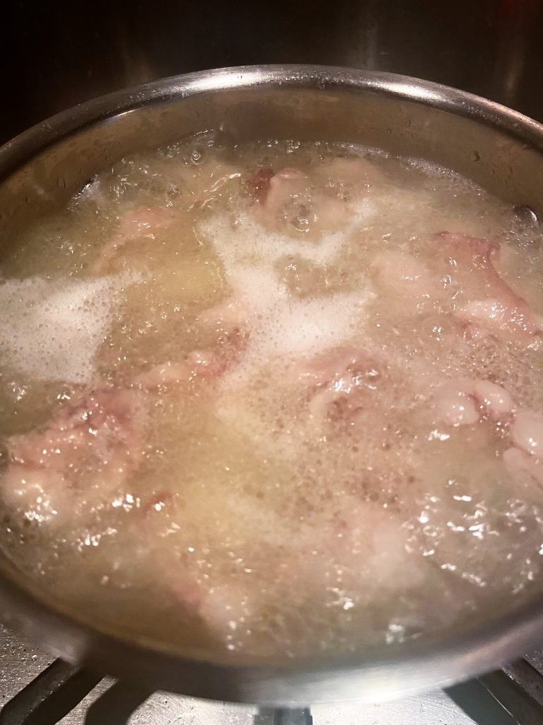 Bring duck fat mixed with water to a boil. Remove foam  and impurities