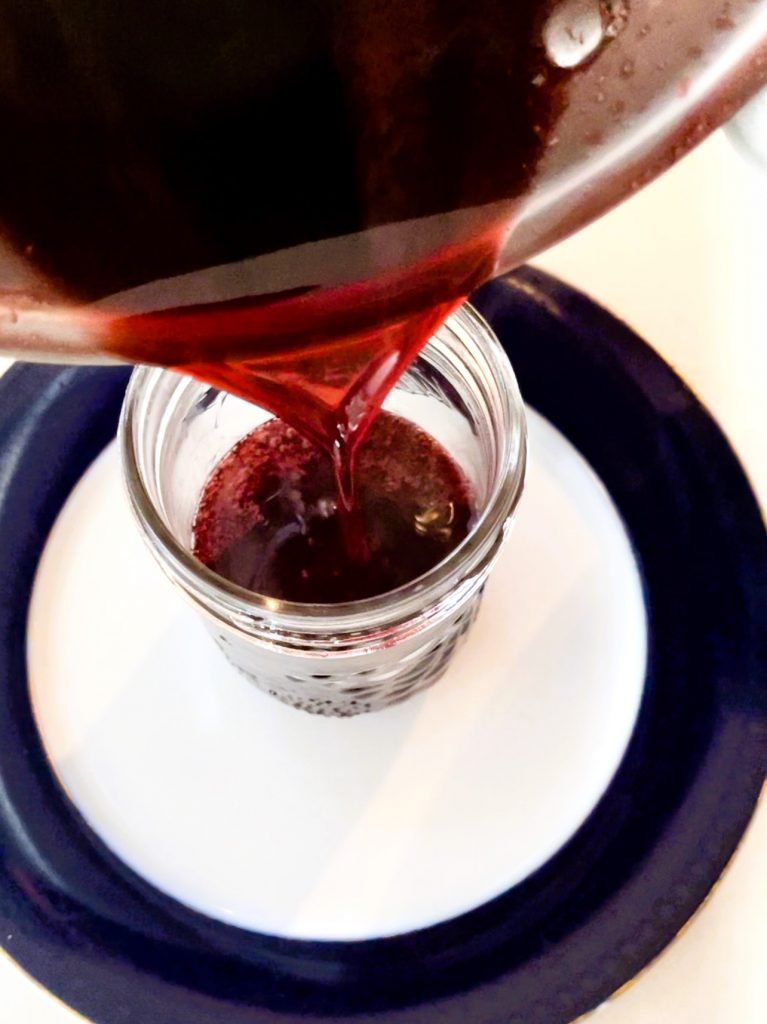 pour hot strawberry syrup into canning jars. 